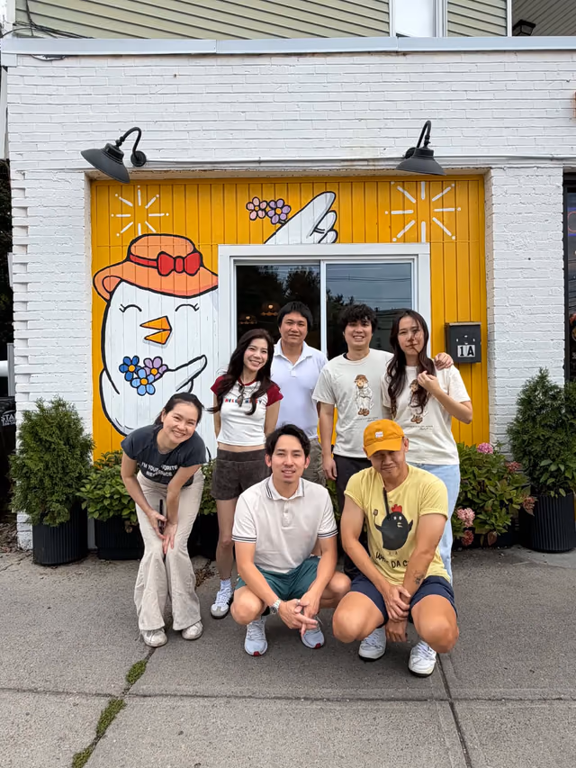 What Da Chick team smiling in front of the mural